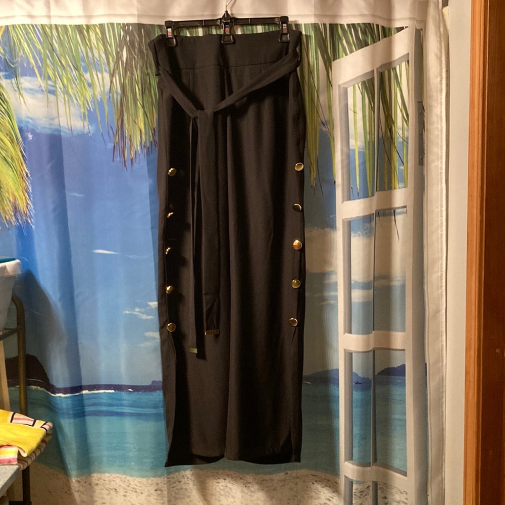 Venus dressy pants. The sides of the pants are brought together by gold buttons.